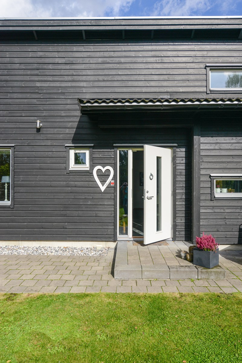 Måla huset? Svart hus med liggande panel och vit entrédörr