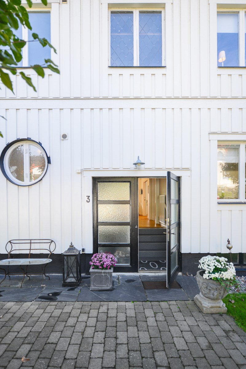 Måla huset? Vitt trähus, entré med öppen dörr