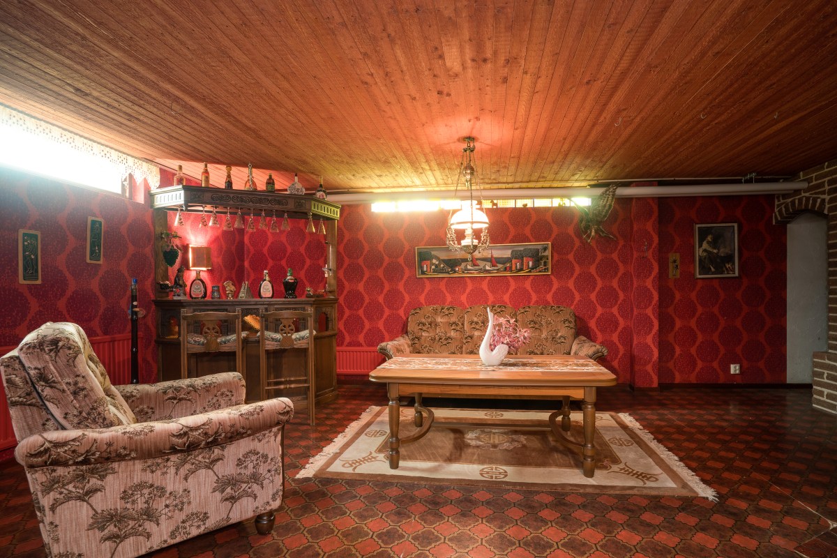 Gillestuga med medaljongtapet i rött och brunrutigt golv