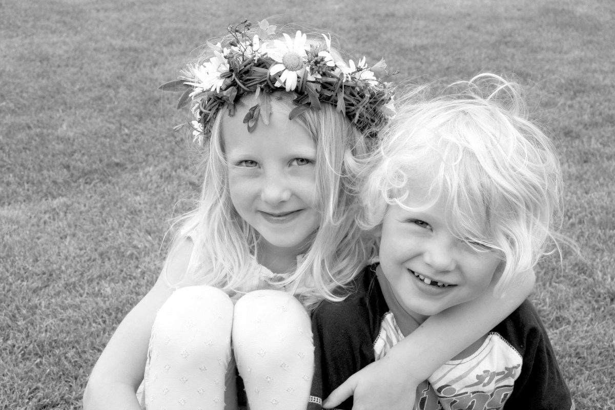 Pojke och flicka med midsommarkrans i håret