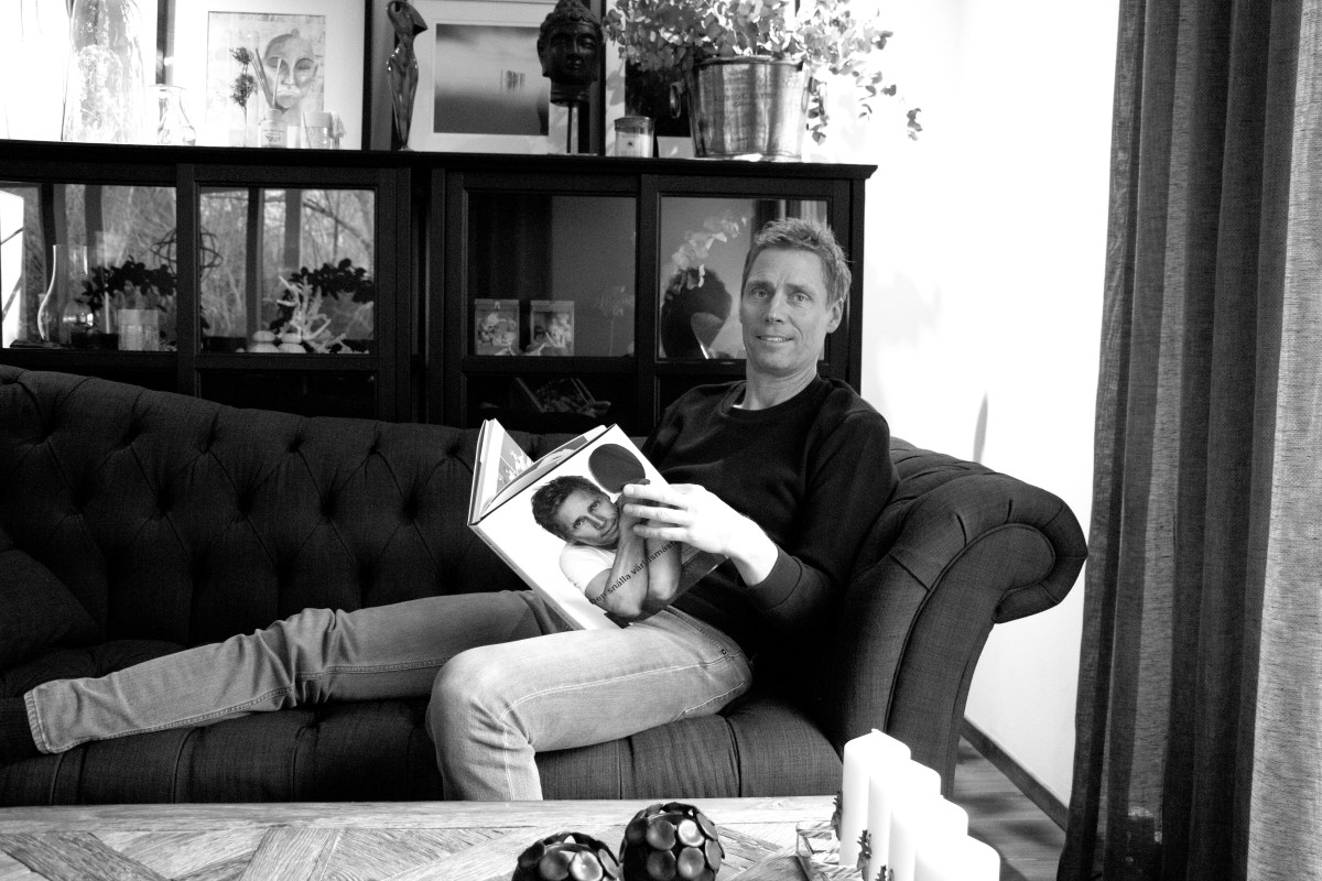 Jörgen Persson bläddrar i sin biografi med det egna porträttet på framsidan "Den snälla Världsmästaren" av Jens Fellke och Helena Egerlind.