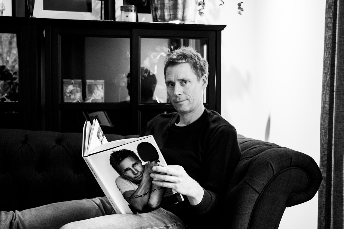 Jörgen Persson bläddrar i sin biografi med det egna porträttet på framsidan "Den snälla Världsmästaren" av Jens Fellke och Helena Egerlind.